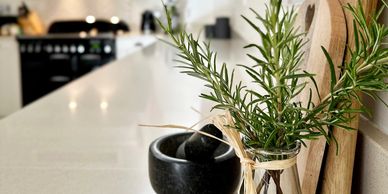 Home styling  for a kitchen including chopping boards, pestle and mortar and fresh rosemary