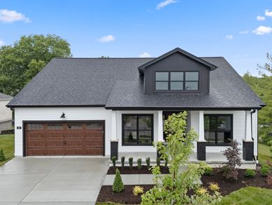 Modern white house with black trim and wooden garage door.
