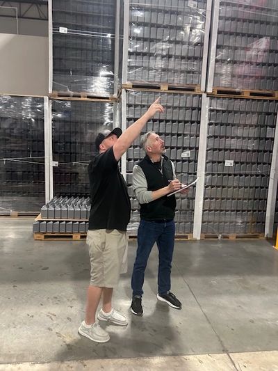 Two men inspecting stock in a warehouse.