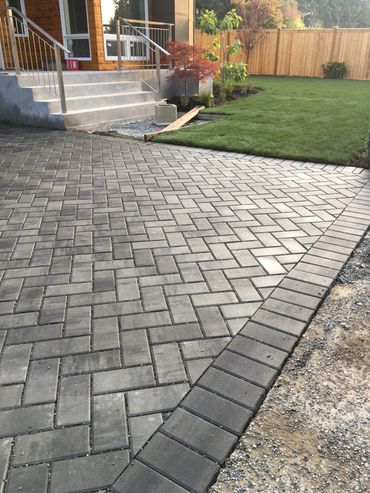 Newly paved driveway with interlocking bricks leading to a house entrance.
