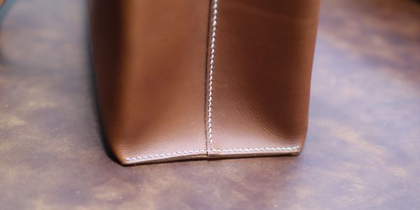 Close-up of brown leather bag stitch.