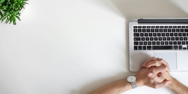 Person relaxing by a laptop on a clean desk.
