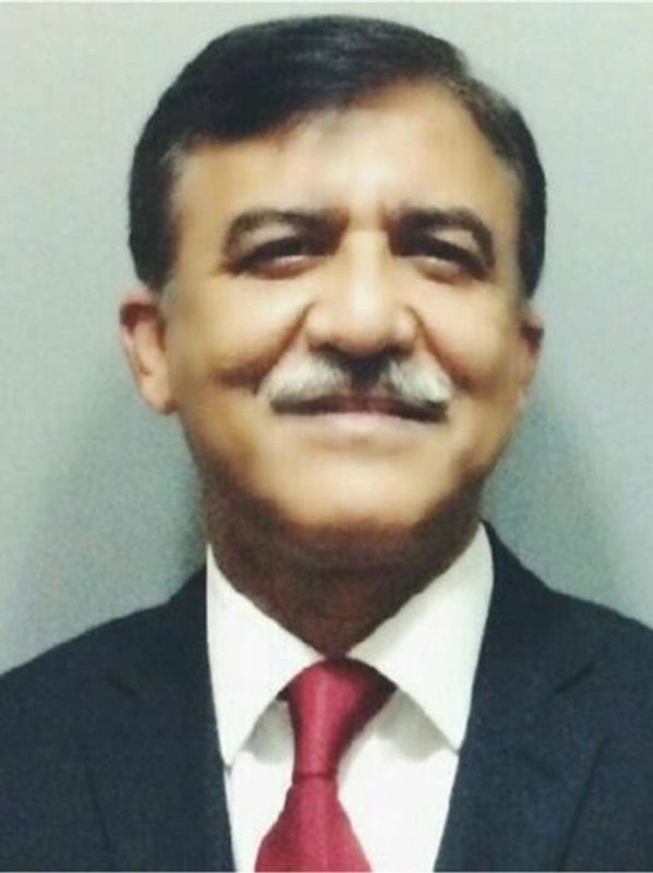 Portrait of a smiling man in a suit with a red tie.