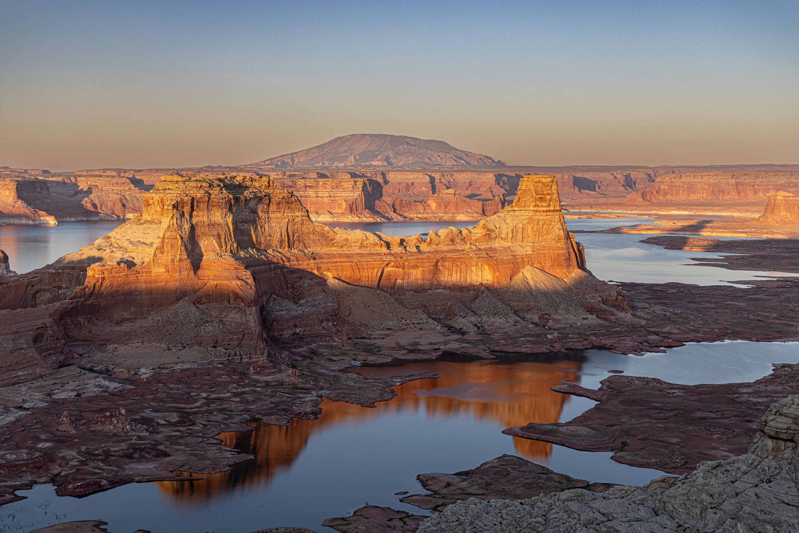 Scenic view of rock formations and a river at sunset.