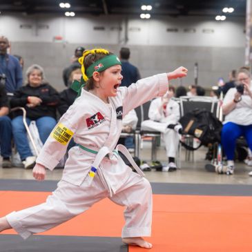 Child performing martial arts move at a competition.