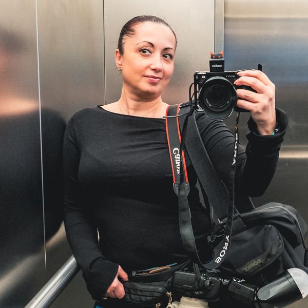 Woman taking a selfie in an elevator with a camera.