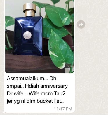 A perfume bottle gift with a heartfelt anniversary message in Malay.