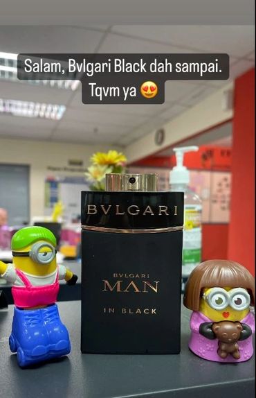 Bvlgari Man In Black perfume with two Minion toys on each side.