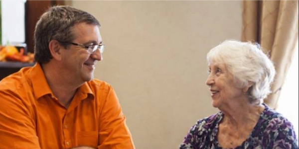 A caretaker taking personalized care of a senior woman
