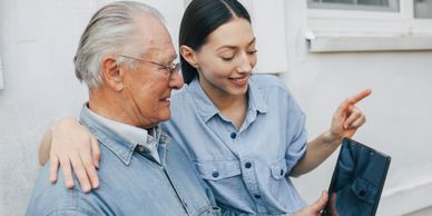 recreational activities where caretaker showing elderly how to use laptops