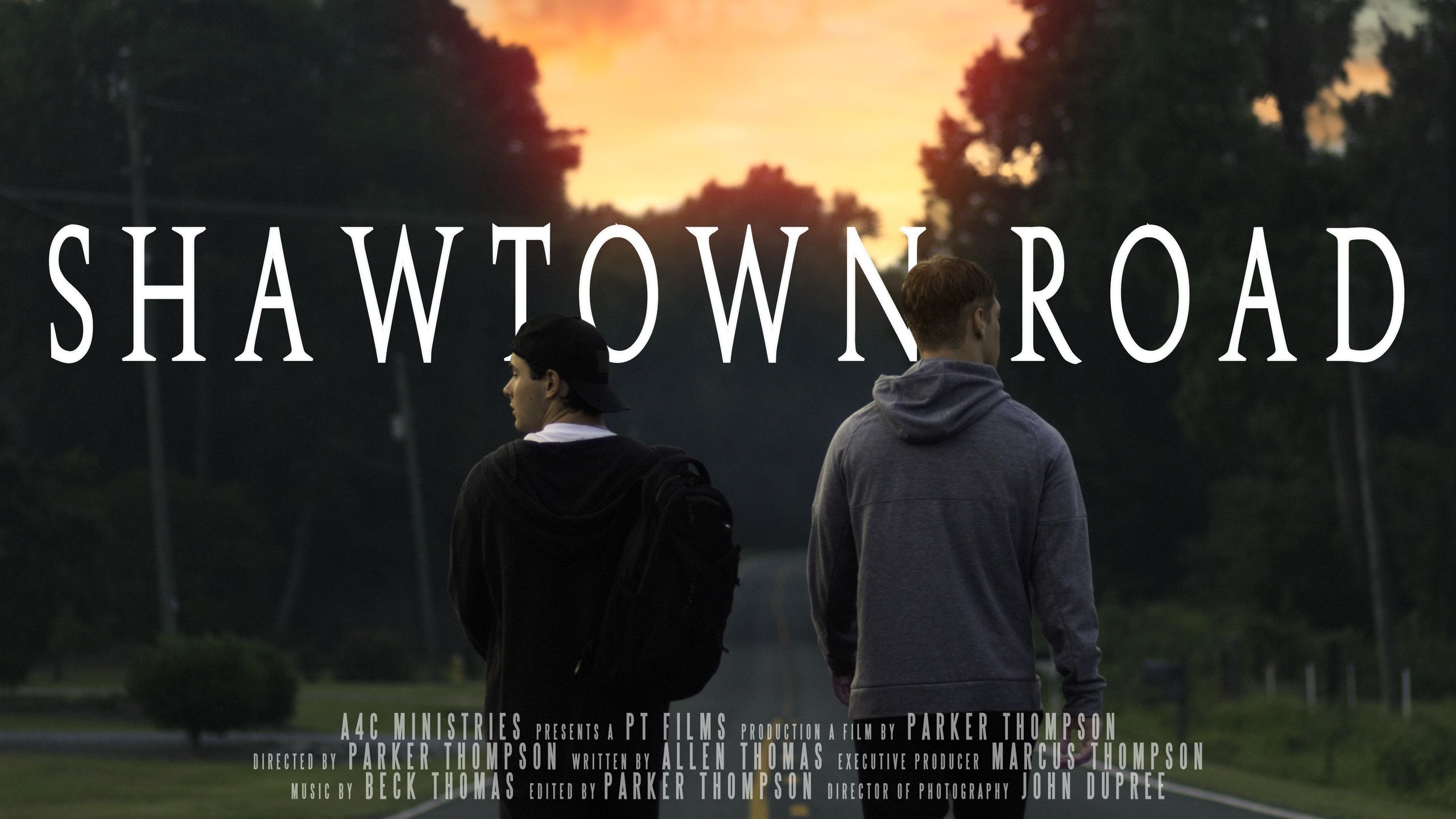 Two young men walking on a road at sunset with the title Shawtown Road.