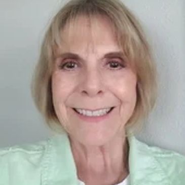 Smiling elderly woman with short blonde hair.