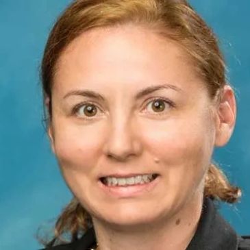 Professional headshot of a woman with light brown hair.