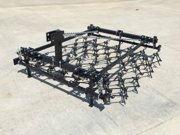 Heavy-duty agricultural harrow on concrete.