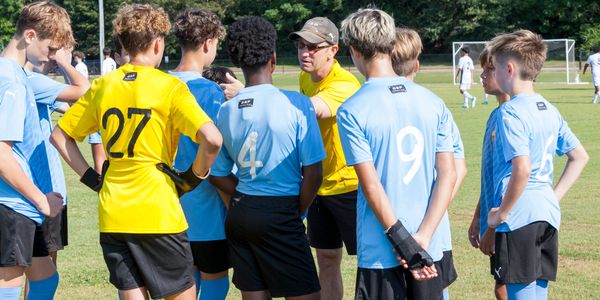 Coach Brian sharing set tactics with team.