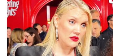 Blonde woman with red lipstick at an event.