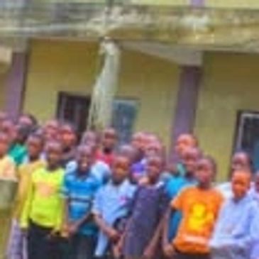 Large group of children lined up outside a school building.