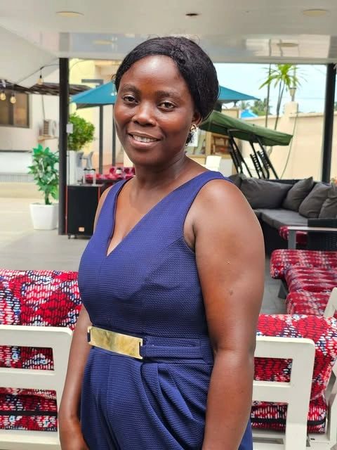 Woman in a blue dress smiling.