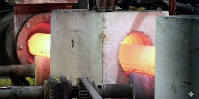 Glowing hot metal pipe being processed in an industrial furnace.