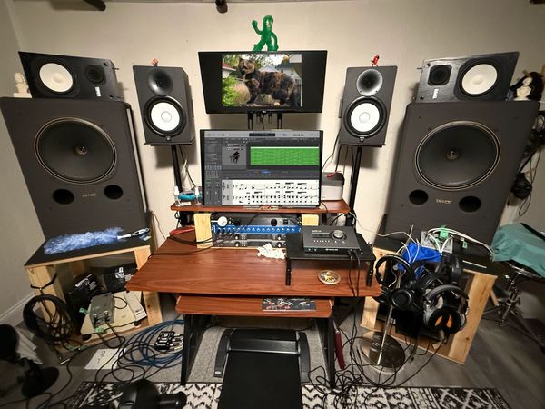 A home music studio setup with large speakers, monitors, and audio equipment.