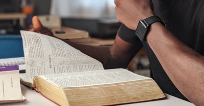 Person reading a large book.