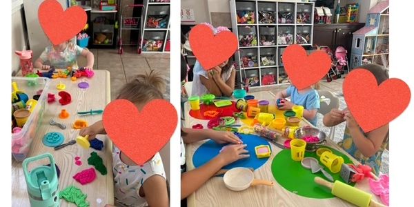 Children playing with colorful playdough at a table in a classroom or playroom.