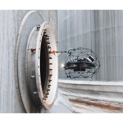 A drone flying near a large industrial circular opening.