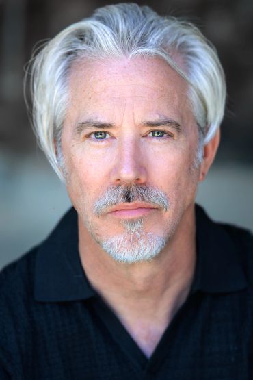 Portrait of a mature man with gray hair and a goatee.