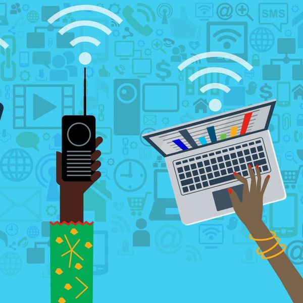 Hands holding walkie-talkie and laptop with Wi-Fi signals.