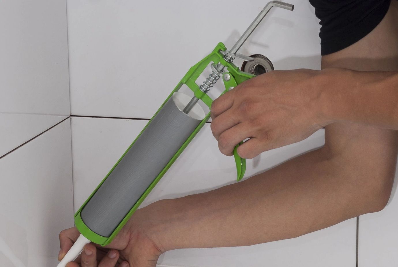 A handyman Caulking a Tub and Shower surround