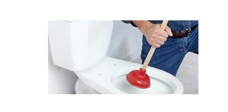 A handyman or plumber fixing a clogged toilet