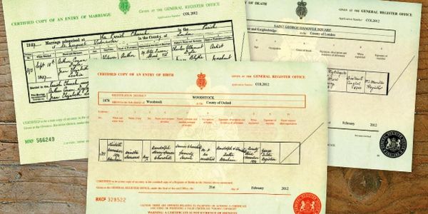 Picture of UK birth, marriage, and death certificates on a table.