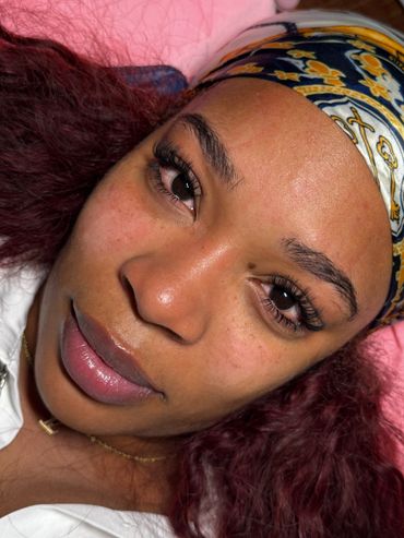 Close-up of a woman with long eyelashes and a colorful headband.
