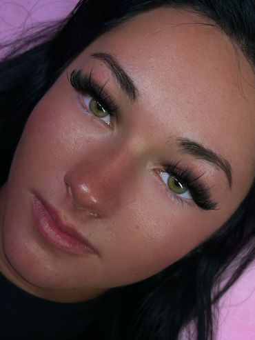 Close-up of a woman with green eyes and long eyelashes.