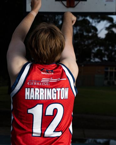 Basketball player wearing a red jersey with number 12 and name Harrington.