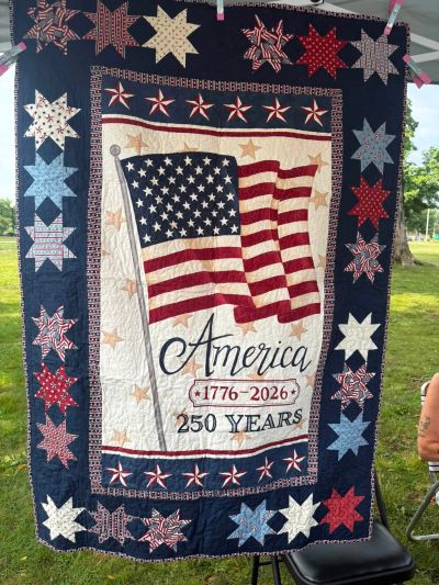 Quilt celebrating America's 250 years with flag and stars.