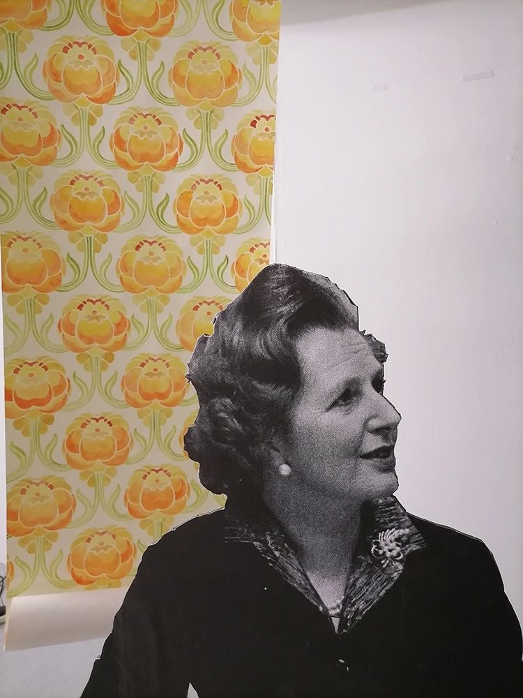 Black and white cutout of a woman against a floral wallpaper background.