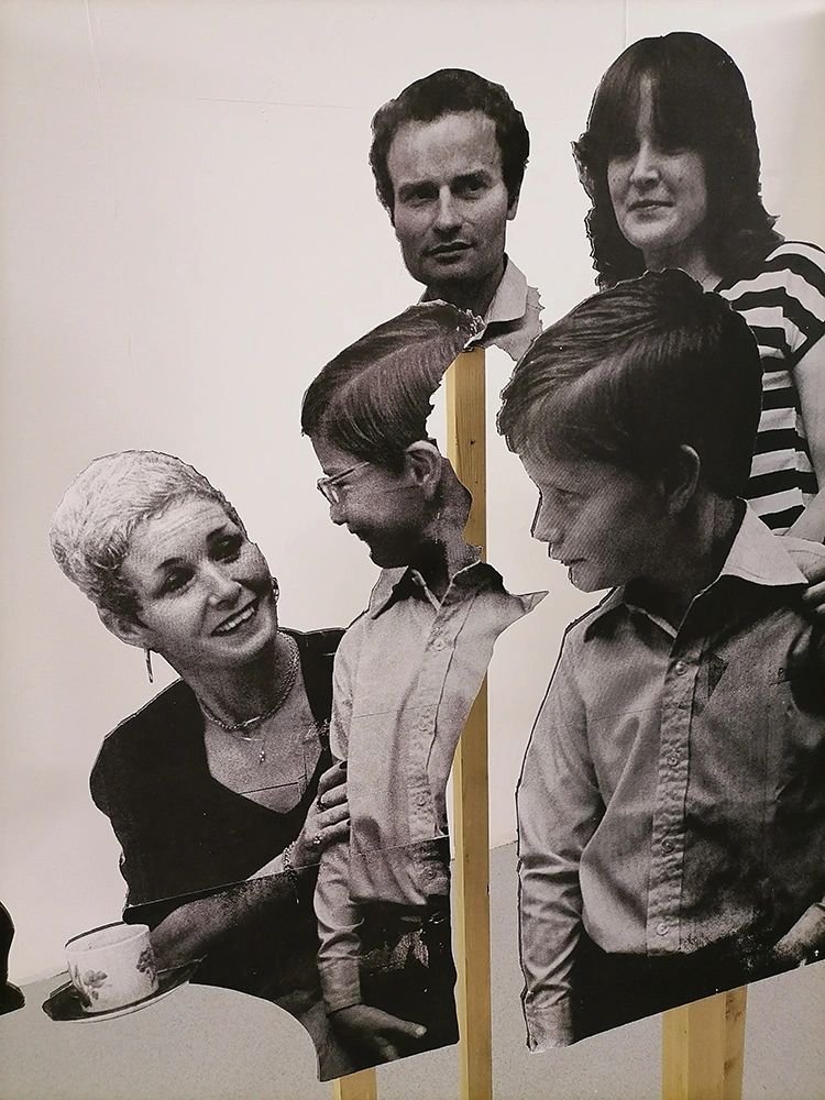 Cutout black and white family photos mounted on wooden stands.