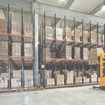 Organized warehouse shelves stacked with boxes and pallet jacks.