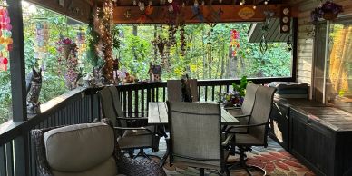 Cozy outdoor patio with chairs and hanging plants.