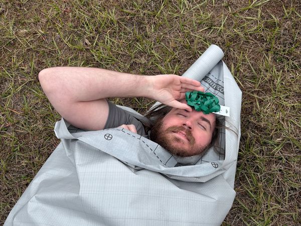 Image of our regional office manager wrapped in a tarp with a bow on his head.
