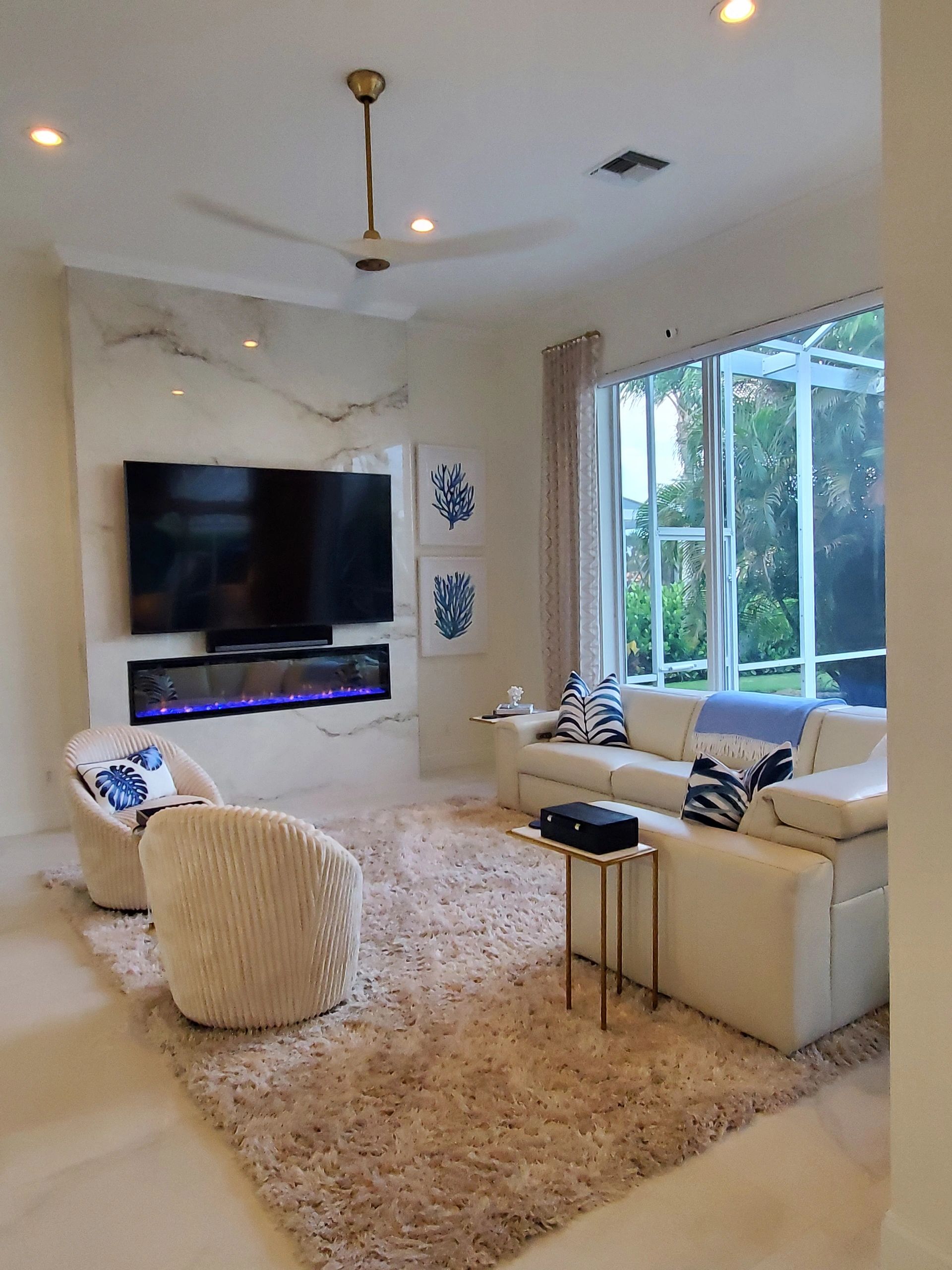 Bright modern living room with white furniture and large window.