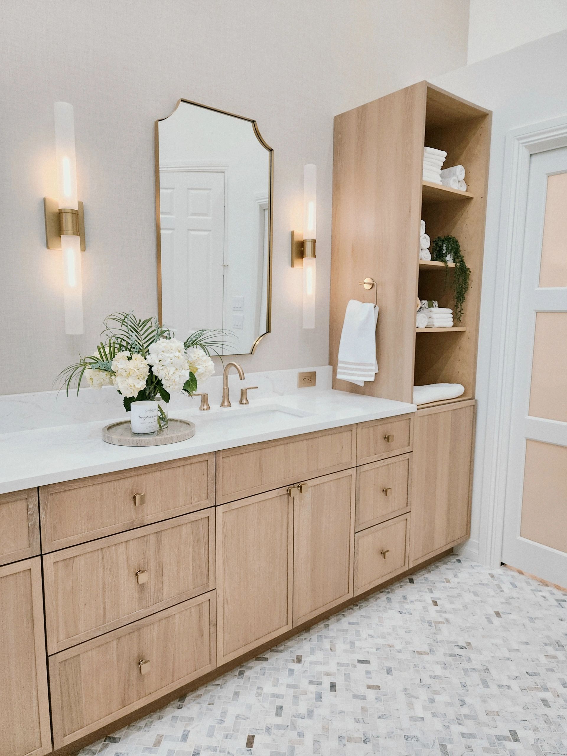 Elegant bathroom with wooden cabinetry and a flower arrangement.