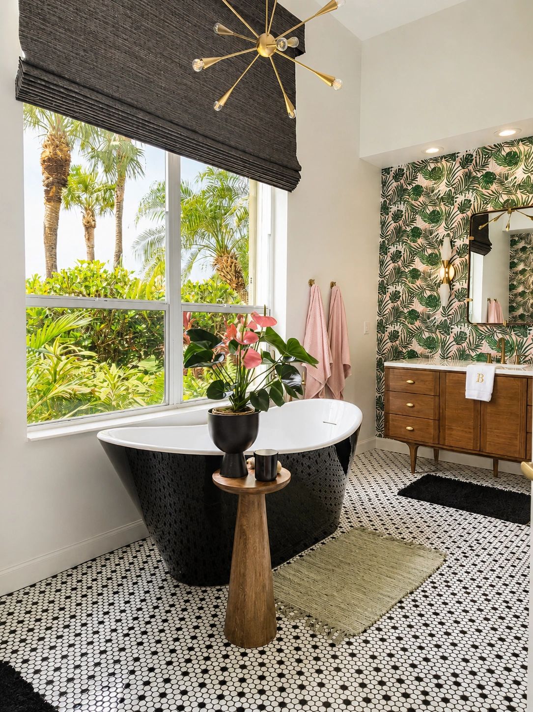 Modern bathroom with a black freestanding tub and tropical wallpaper.