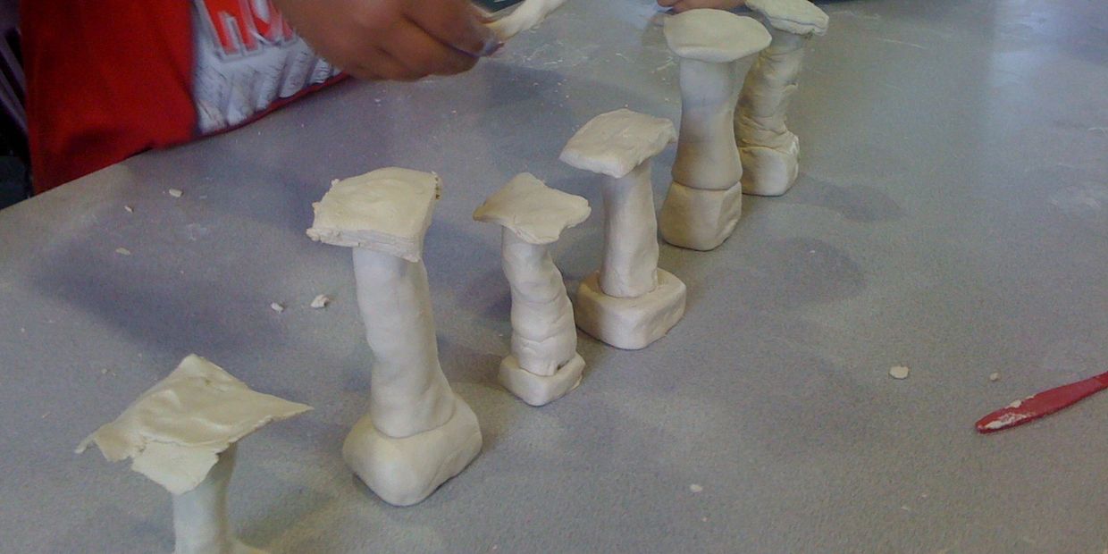 Kids buiding greek columns using clay