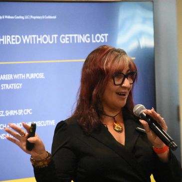 Woman speaking at a seminar with a microphone.
