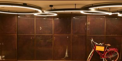 A red bicycle parked indoors with circular ceiling lights.