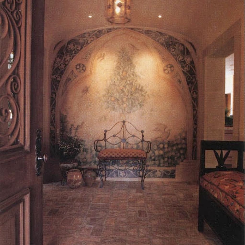 Cozy Mediterranean-style seating area with wrought iron chairs and mural.