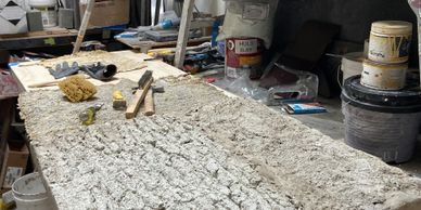 A textured art piece in progress on a messy studio table.