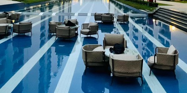 Modern apartment buildings with a reflective pool and seating area in the center.